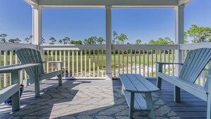 A covered outdoor area with a view of a golf course, featuring a covered seating area with benches and a table. - NEW LISTING! Lost Key Villas Golf & Beach Club ~Sea Salt - NO HASSLE CHECK OUT (Perdido Key)