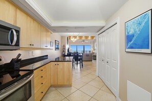 Una cocina con armarios de madera, microondas y un comedor con vistas.