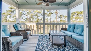 A covered porch with wicker furniture, a ceiling fan, and a view of trees. - Lost Key Villas Golf & Beach Club ~Shore to Please - NO HASSLE CHECK OUT (Perdido Key)