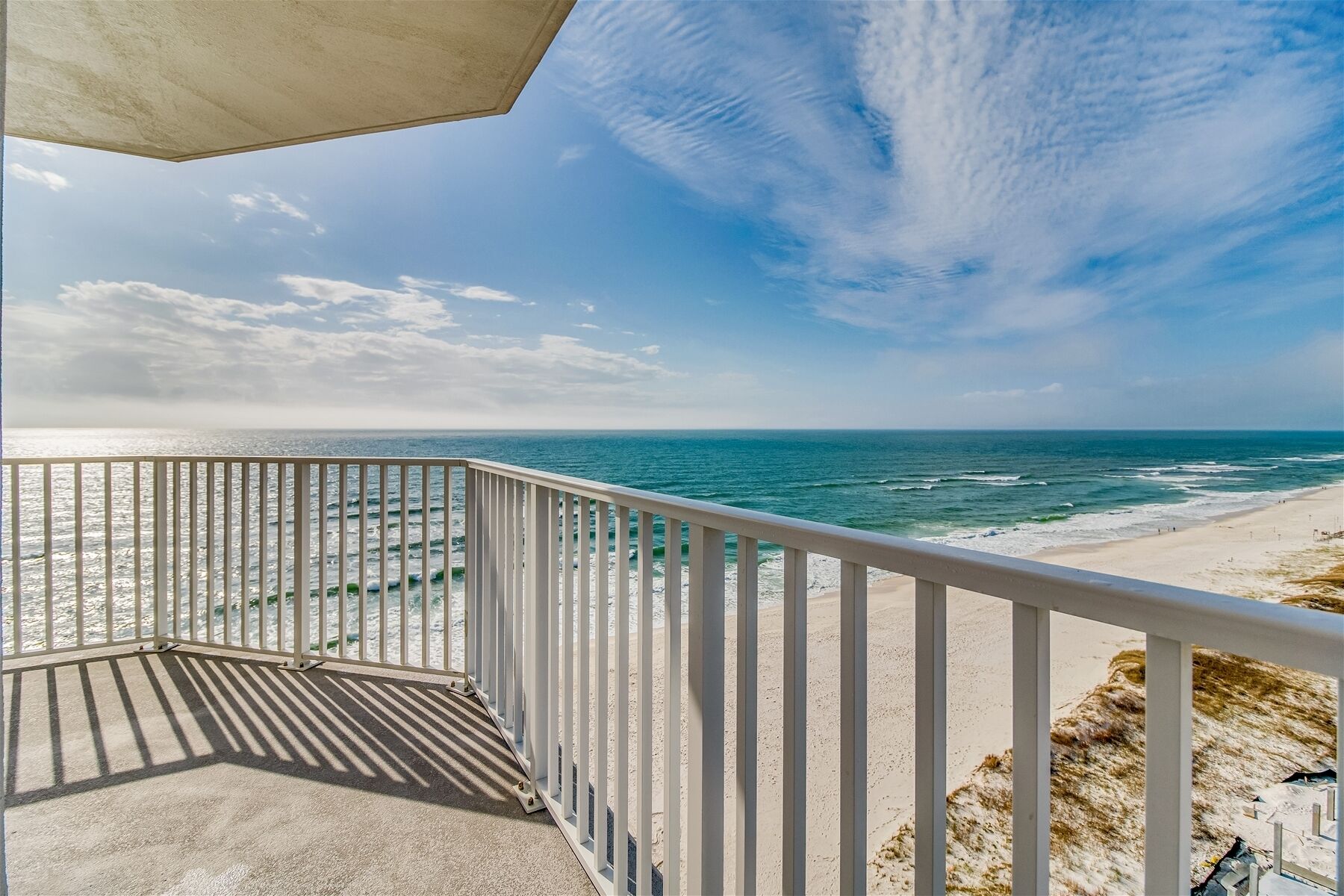 Een balkon met uitzicht op de oceaan en het strand.