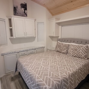 A bedroom with a bed, a dresser, and a nightstand.