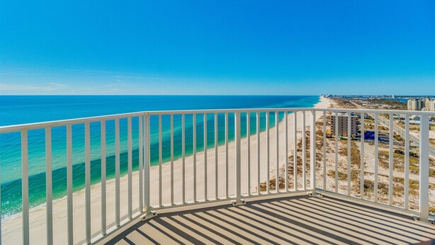 Un balcon avec vue sur une plage et l’océan.