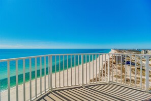 Un balcon avec vue sur une plage et l’océan.