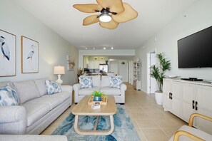 A living room with a sofa, coffee table, and a television.