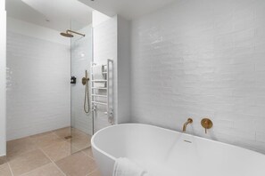 A modern bathroom with a glass-enclosed shower, a freestanding bathtub, and white tiled walls. - Cosy Beach House on the Seafront, Porthleven (Helston)