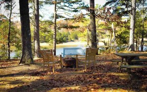 Situated in a wooded area, this serene space offers a bench and picnic table for relaxation and social gatherings.