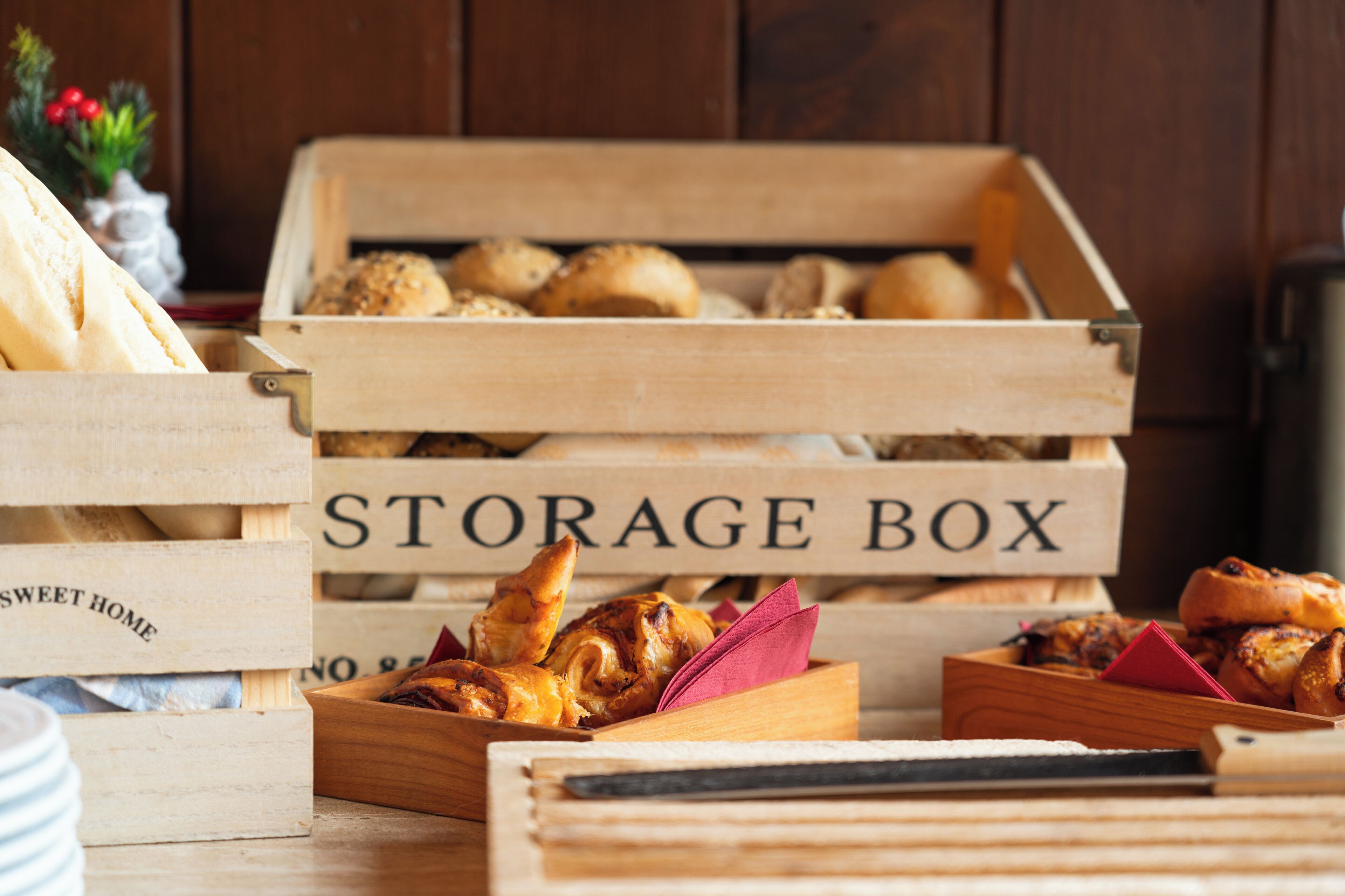 A wooden crate labeled "STORAGE BOX" containing various baked goods.