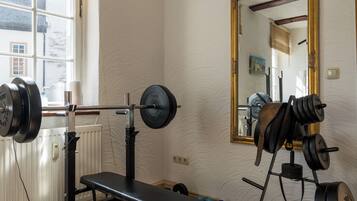 A gym with a bench, barbell, and weight plates.