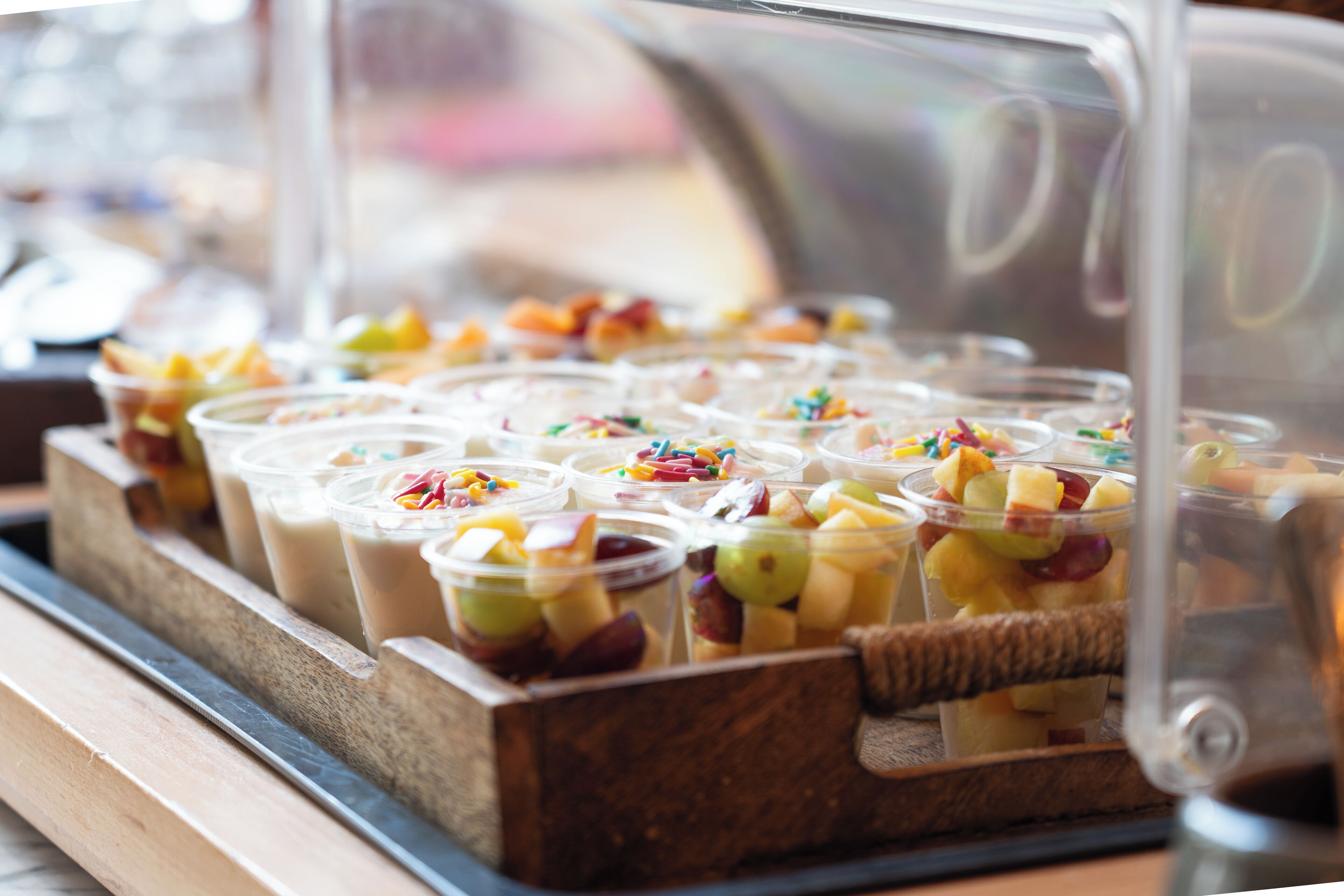 Eine Vitrine mit verschiedenen Frucht- und Joghurt-Parfaits.