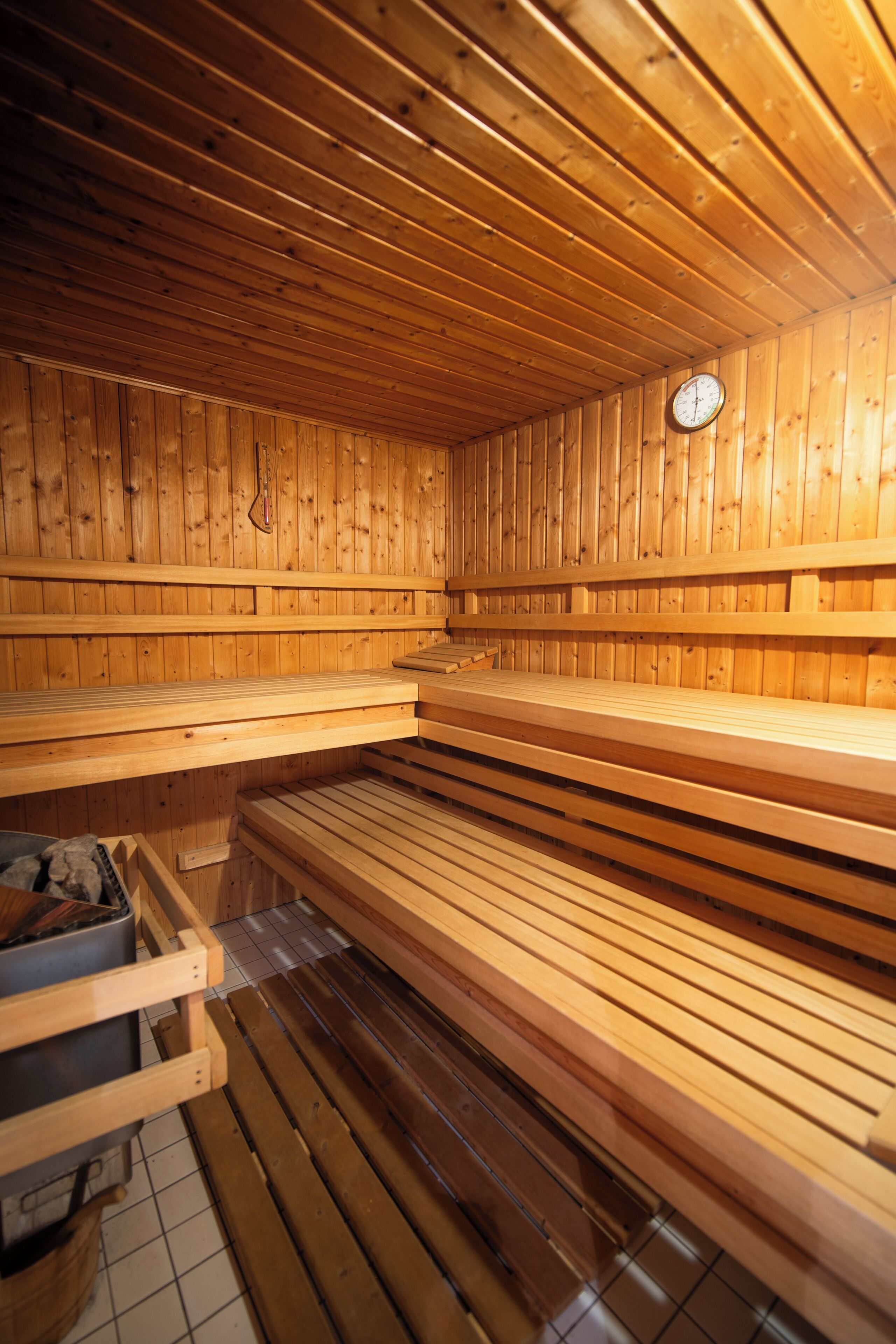 Eine Sauna mit Holzbänken und einer Uhr an der Wand.