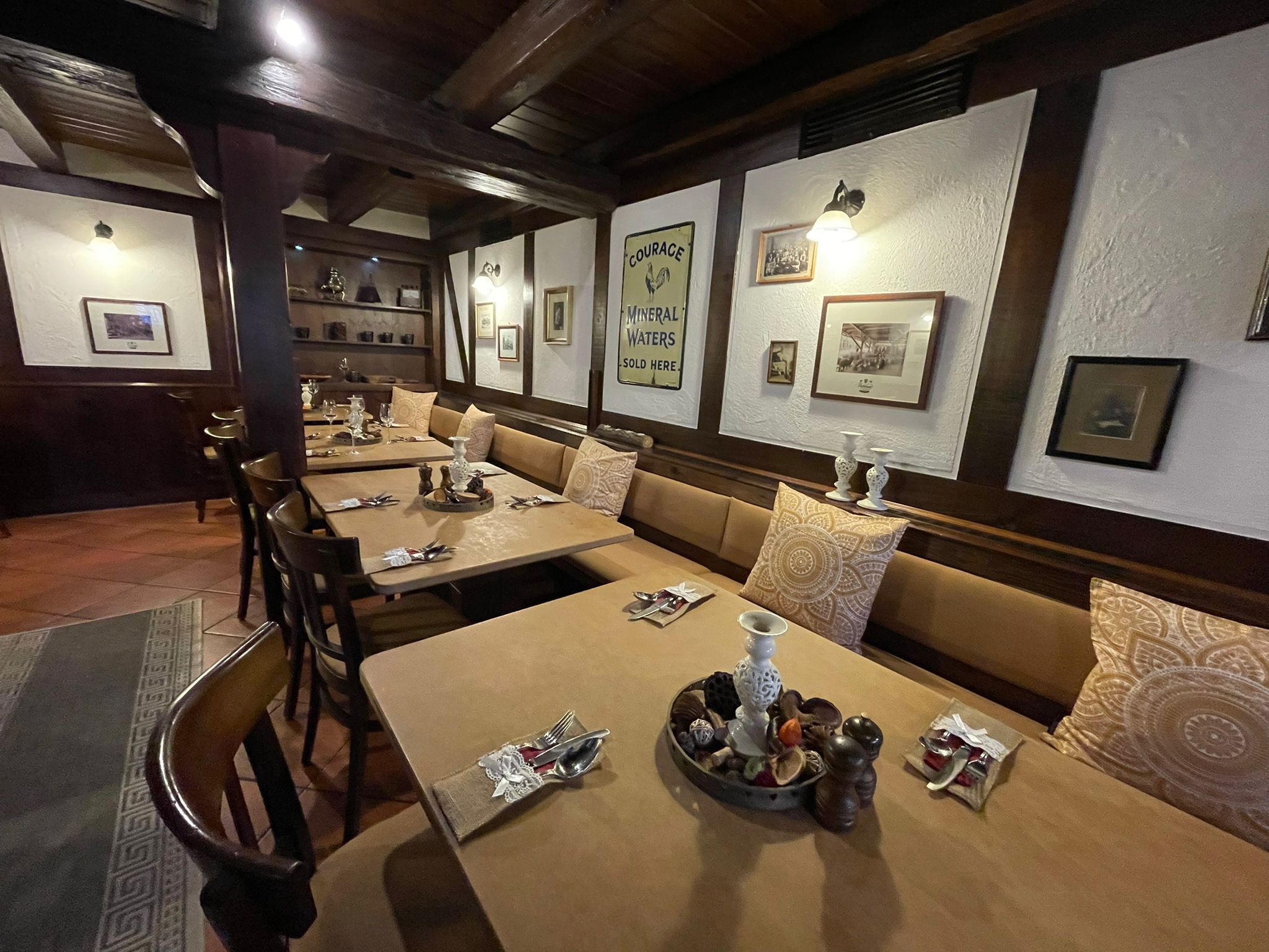 A restaurant with booths and tables, each set with cutlery and condiments.