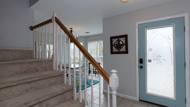 A staircase with white railings and a wooden handrail leading to a room with a blue door. - Charming Townhouse - great walkable area 5 min from Downtown (Columbus)