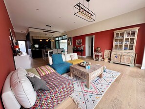 A modern living room with a sofa, coffee table, and a red accent wall.