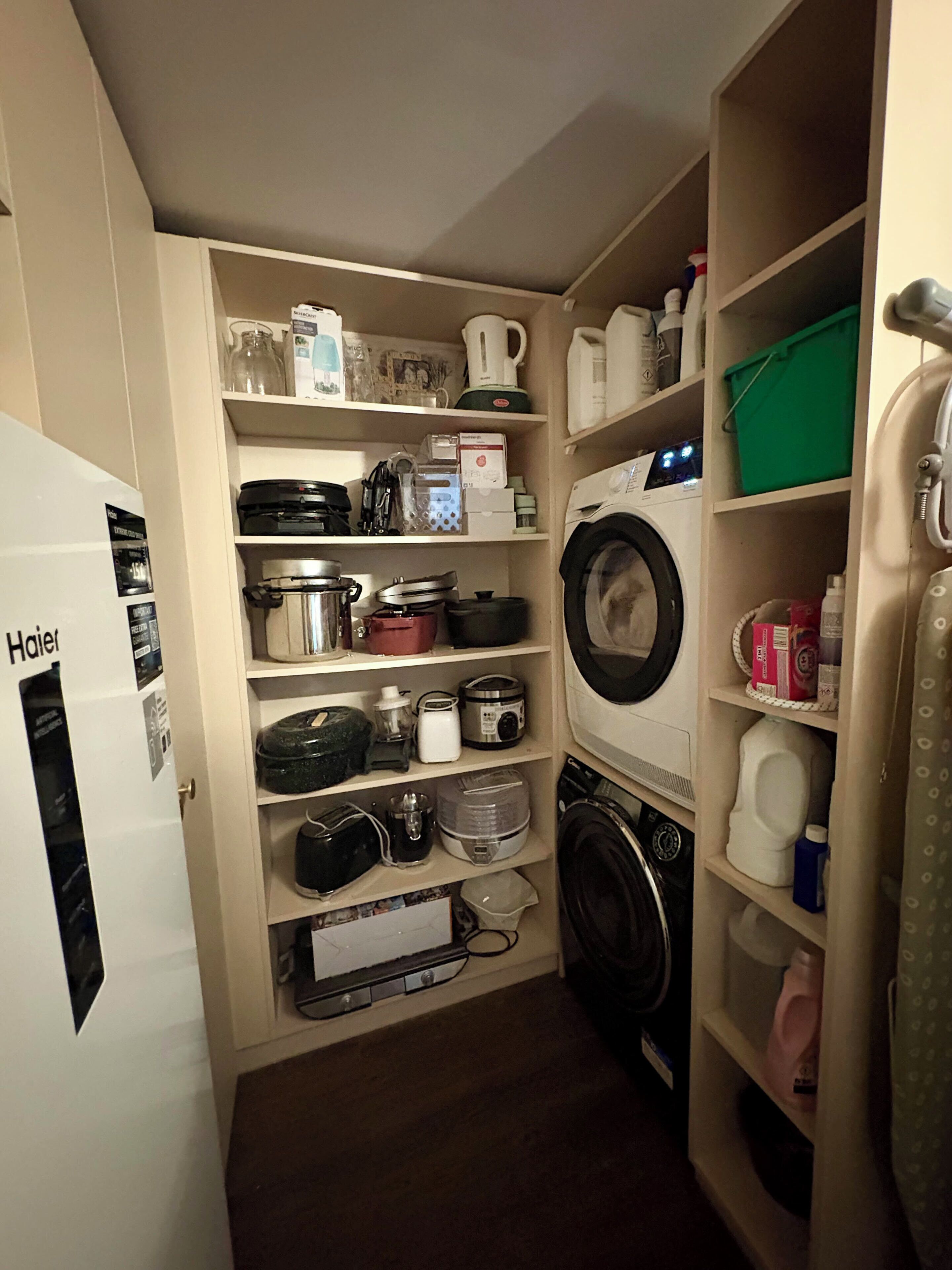 Une cuisine compacte équipée d’un réfrigérateur, d’une cuisinière, d’un four à micro-ondes et d’un lave-linge.