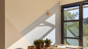 Un comedor con una mesa de madera, seis sillas y plantas en macetas.