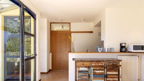 Una cocina moderna con un armario de madera, un microondas y una cafetera.