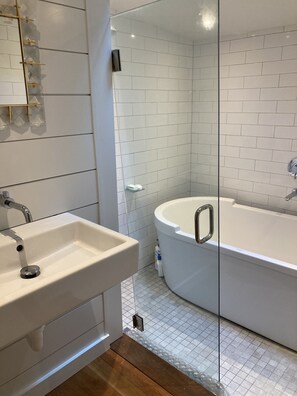 Bathroom features a bathtub, sink, and glass shower enclosure.