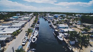 A marina with boats docked along a narrow waterway, surrounded by RVs and mobile homes. - Vacation Paradise478 (Key Largo)