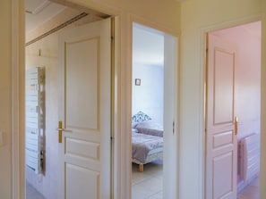 Une pièce comprenant un lit, un radiateur et une porte donnant sur une autre pièce.