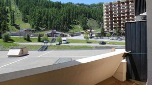 A view of a parking lot with a small building, a bus, and a mountain in the background. - 100m from ski slopes, 1st floor, balcony, tv, ski locker, 38m², Vars (Vars)