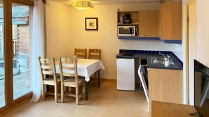 A compact kitchen with a dining area, a microwave, a coffee maker, and a refrigerator. - Floor -1, view ski slopes, swimming pool, sauna, balcony, tv, ski locker, 29m², Les Orres (Les Orres)