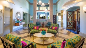 Relax in style with a round table and four armchairs, surrounded by a decorative mirror and crystal chandeliers.