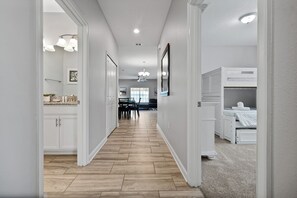 Un couloir menant à une salle à manger avec vue sur l’extérieur.