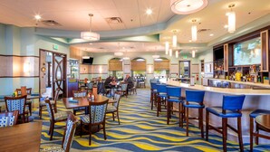 A hotel lobby with a bar area, multiple seating arrangements, and a patterned carpet. - Make your own Escape to Disney in this fantastic pool townhouse! (Davenport)