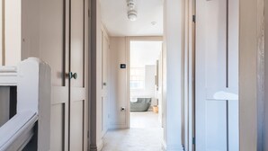 A hallway with white doors, a visible light switch, and a ceiling light fixture.