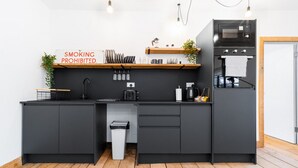 A modern kitchen with a black countertop, a built-in oven, and a sign prohibiting smoking. - Newtown Lofts - Luxe Apartment - Parking (Birmingham)