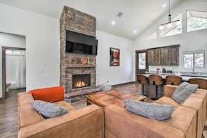 Cozy living room with a fireplace, leather sofas, and a dining table.