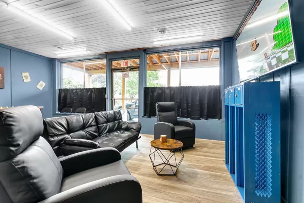 A modern lounge area with leather sofas, a coffee table, and a blue locker area.