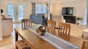 A modern living room with a dining area, a sofa, a TV, and a ceiling fan. - The Quail's Nest! Convenient to downtown, quiet and fully remodeled! (Thomasville)