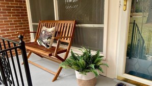 A wooden bench with a cushion, a potted plant, and a welcome mat outside a door. - The Quail's Nest! Convenient to downtown, quiet and fully remodeled! (Thomasville)