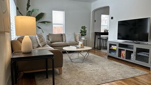 Ein modernes Wohnzimmer mit Sofa, Couchtisch, Fernseher und Unterhaltungseinheit.