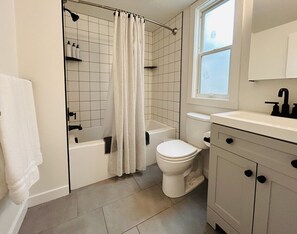 Un baño moderno con bañera, inodoro y lavamanos.