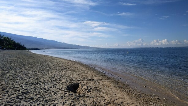 Una spiaggia con cielo sereno e acqua calma.