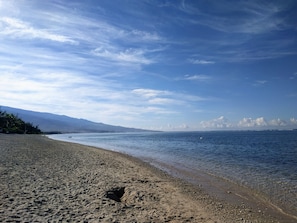A beach with a clear sky and calm water.