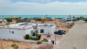 A coastal residential area with modern houses, a paved road, and a view of the sea. - Casa Marimar with private heated pool at Laguna Shores Resort (Puerto peñasco)
