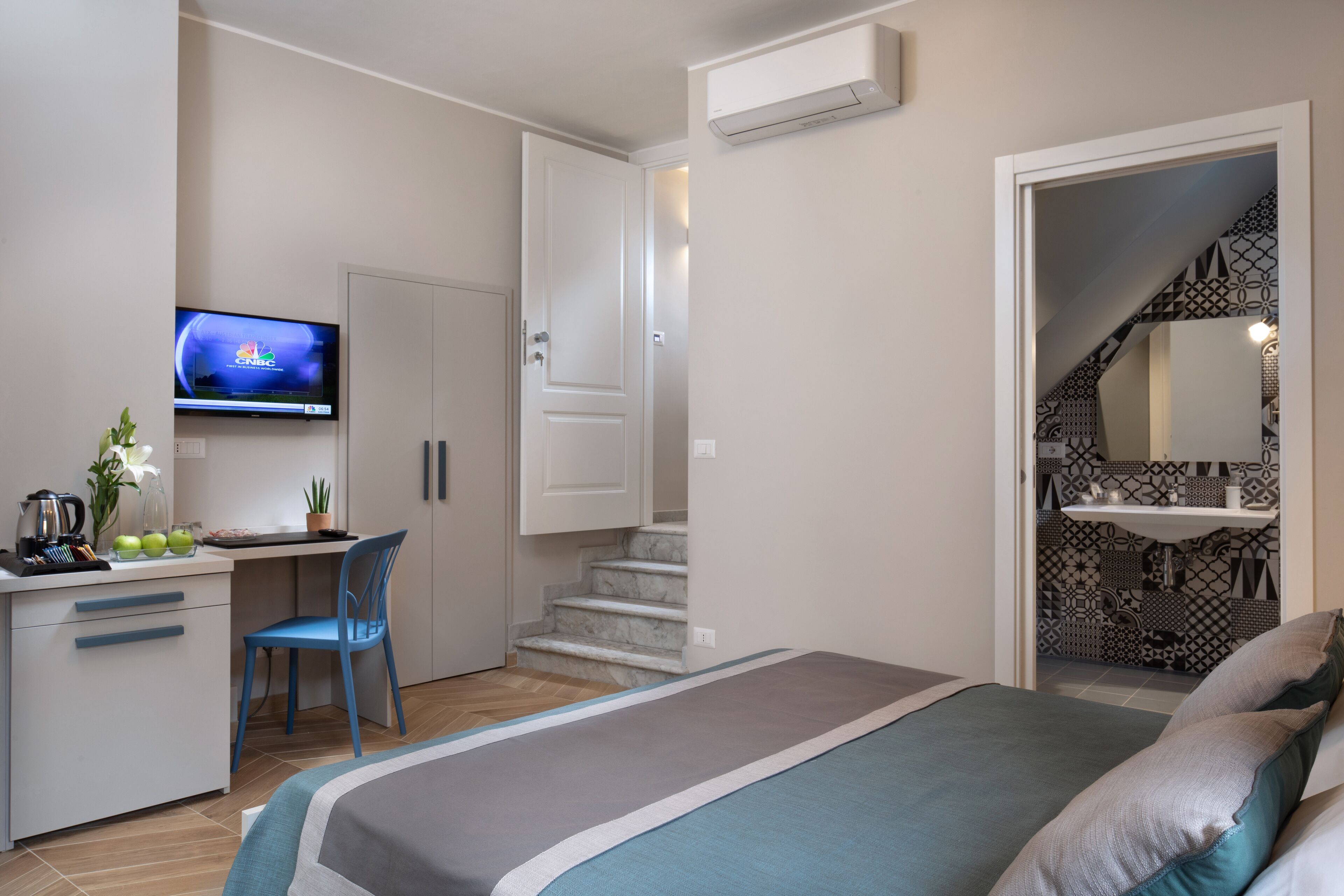 Une chambre à coucher avec un lit, un bureau, une chaise et un téléviseur.