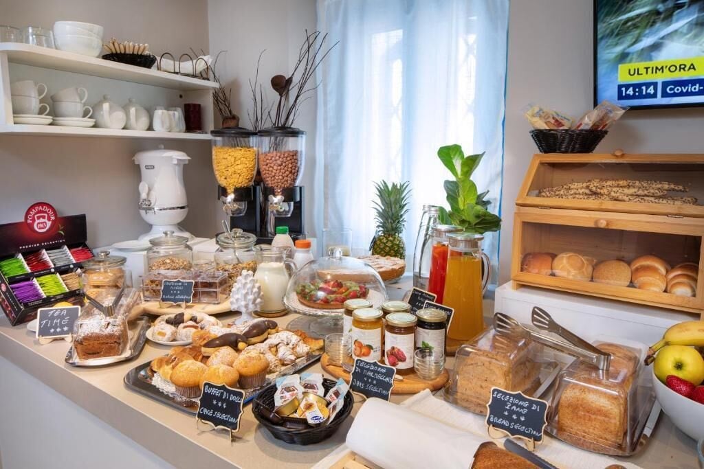 Un bufé de desayuno con diversas opciones de comida, incluyendo bollería, pan y salsas.