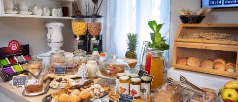 A breakfast buffet with various food items, including pastries, bread, and condiments.
