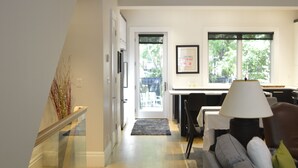Ein modernes Interieur mit einer Treppe, einem Essbereich und einem Wohnzimmer mit Sofa und Lampe.