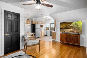 Cozy living space with a dining area, kitchen, and flat-screen TV.