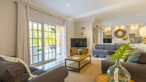 A living room with a sofa, coffee table, and a TV.