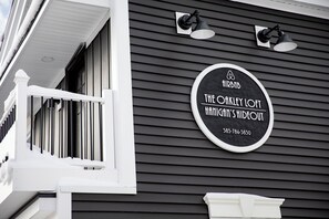 Un letrero blanco y negro con el texto "The Oakley Loft" y un número de teléfono.