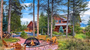 A lodge with a fire pit, outdoor seating, and a view of the surrounding forest. - Family-friendly cabin near Winter Park w/ hot tub (Fraser)