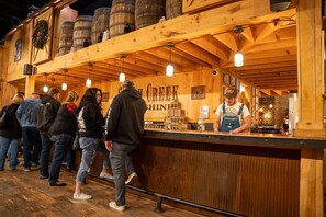 Enjoy a drink at the rustic bar, where friendly bartenders serve guests amidst wooden beams and barrels.