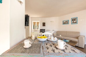 A cozy living room with a beige sofa, a coffee table with a bowl of lemons, and two framed pictures on the wall.
