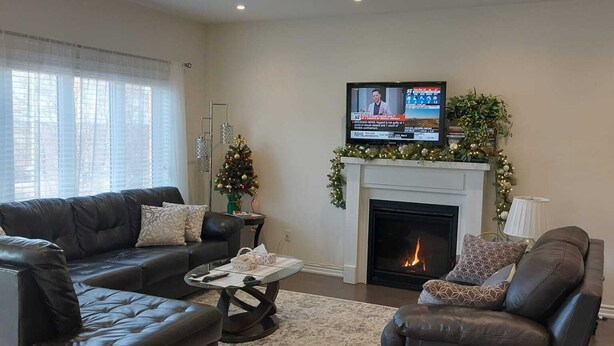 Ein Wohnzimmer mit Kamin, Fernseher und Weihnachtsbaum.
